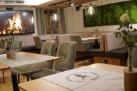 ErgoldsbachにあるHotel Gasthof Stieglersのテーブルと椅子と暖炉のあるレストラン