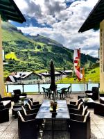 a patio with tables and chairs and a view of a mountain at Pension Weinberger in Obertauern