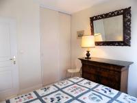 a bedroom with a bed with a dresser and a mirror at Royan - Résidence VILLA BRACELLI - APPARTEMENT SPACIEUX - Centre-ville in Royan