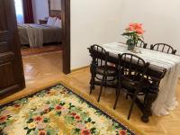 a dining room with a table and chairs and a rug at Zentrum Vintage Appartments in Braşov