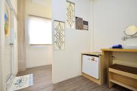 a room with a refrigerator and a desk and a window at Jamie home stay in Taitung City