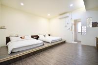 two beds in a bedroom with white walls and wooden floors at Jamie home stay in Taitung City