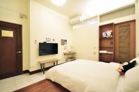 a bedroom with a bed and a flat screen tv at Jamie home stay in Taitung City