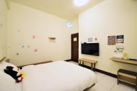 a bedroom with a bed and a tv on the wall at Jamie home stay in Taitung City
