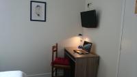 a bedroom with a desk with a laptop computer on it at Hotel TGV in Quimper