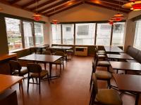 Oyado Tamayura في نوزاوا أونسن: غرفة طعام مع طاولات وكراسي ونوافذ