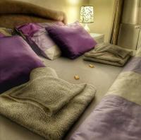 a bedroom with purple and white pillows on the floor at TOP Apartman in Šabac