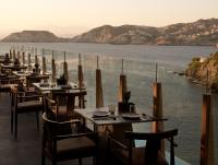 um restaurante com mesas e cadeiras com vista para a água em Acro Suites - A Wellbeing Resort em Agia Pelagia