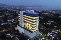 Un edificio alto con un cartel encima. en Golden Tulip Springhill Lampung, en Bandar Lampung