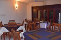 a dining room with tables and chairs with blue table cloth at Emarald Holiday Homes in Anuradhapura