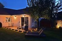 a backyard with a wooden deck with a tree and lights at Guest house avec spa Jura , gîte du petit pommier 