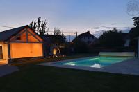 a swimming pool in the yard of a house at Guest house avec spa Jura , gîte du petit pommier 