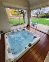 a jacuzzi tub in a house with a porch at Guest house avec spa Jura , gîte du petit pommier 