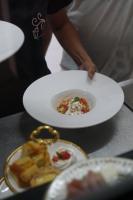 une personne tenant une assiette blanche avec un bol de nourriture dans l'établissement Villa dos Poetas, à Barra Grande