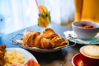 Una mesa con un plato de pasteles y una taza de café. en AeroCafe, en Partizánske