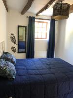 a bedroom with a blue bed and a window at Gîte Ker Corsica in Retiers