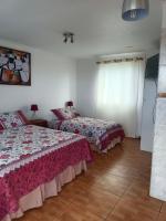 Un dormitorio con dos camas y una ventana. en cabañas Te Pito Kura, en Hanga Roa