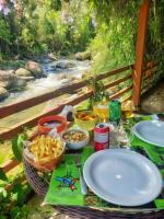 una mesa de picnic con platos de comida y una cesta de patatas fritas en Repousada Sana, en Sana