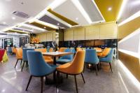 a restaurant with blue and orange chairs and tables at 56 Hotel in Kuching