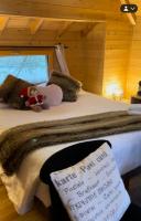 a bed with a teddy bear sitting on top of it at Cabane perchée luxe avec jacuzzi Domaine du Marais Maisse in Maisse
