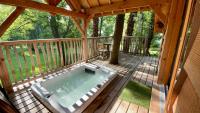 a screened in deck with a hot tub on a porch at Cabane perchée luxe avec jacuzzi Domaine du Marais Maisse in Maisse