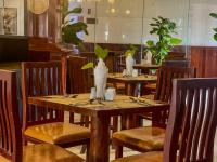 a table in a restaurant with wooden chairs and plants at Harmony Indochine d'Angkor in Siem Reap