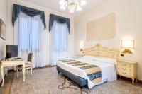 a bedroom with a bed and a desk and a table and a chair at Hotel Torino in Venice