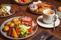a table with plates of food and a cup of coffee at Konventa Sēta Hotel Keystone Collection in Riga