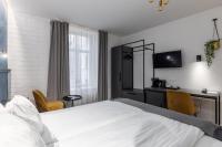 a bedroom with a white bed and a desk with chairs at Konventa Sēta Hotel Keystone Collection in Riga