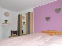 a bedroom with a bed with purple walls and hearts on the wall at Pension Neuenrade in Neuenrade