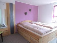 a bedroom with a wooden bed with a purple wall at Pension Neuenrade in Neuenrade