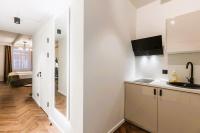 a kitchen with white cabinets and a sink in a room at Konventa Sēta Hotel Keystone Collection in Riga
