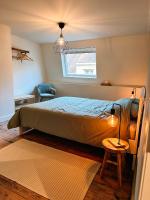 a bedroom with a bed and a chair and a window at Vakantiehuis Maison Madeleine centrum Ieper in Ieper