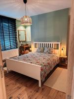 a bedroom with a large bed and a mirror at Vakantiehuis Maison Madeleine centrum Ieper in Ieper