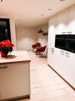 a kitchen with white appliances and red chairs at Vakantiehuis Maison Madeleine centrum Ieper in Ieper