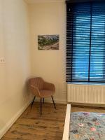 a chair sitting in a room with a window at Vakantiehuis Maison Madeleine centrum Ieper in Ieper