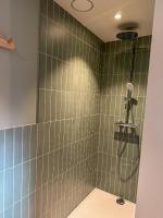 a bathroom with a shower with green tiles at Vakantiehuis Maison Madeleine centrum Ieper in Ieper