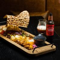a table with a tray of food and a bottle of beer at Konventa Sēta Hotel - Keystone Collection in Rīga