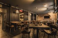 a restaurant with tables and chairs and a brick wall at Konventa Sēta Hotel - Keystone Collection in Rīga