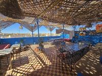un patio con mesas y sillas bajo un techo en Panorama chez Hamid, en Rissani