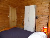a bedroom with a bed in a wooden cabin at Les Mathes La Palmyre - MAISON CABANE des TRAPPEURS - PROCHE COMMERCES in Les Mathes