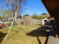 a swing set in the yard of a house at Les Mathes La Palmyre - MAISON CABANE des TRAPPEURS - PROCHE COMMERCES in Les Mathes