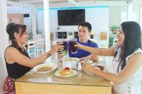 eine Gruppe von Menschen sitzt um einen Tisch herum und isst in der Unterkunft Hotel Boca Raton Tarapoto in Tarapoto
