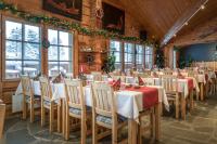 Un comedor con mesas y sillas y ventanas. en Hotel Kuusamon Portti, en Kuusamo