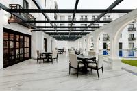 a dining area with tables and chairs in a building at Ramada by Wyndham Goa Vagator in Vagator