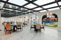 a dining room with tables and chairs and a courtyard at Ramada by Wyndham Goa Vagator in Vagator