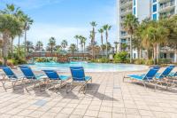 einen Pool im Resort mit blauen Stühlen und Palmen in der Unterkunft Marvelous 9th Floor Condo Gulf, Pool &amp; Sunset View in Destin