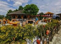 ein Restaurant mit Tischen und Stühlen im Garten in der Unterkunft Apartmánový dom v Panoráma Parku in Nezbudská Lúčka