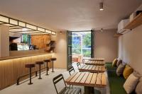 メデジンにあるAntipoda Hotel Boutiqueのテーブルと椅子、緑のソファが備わるレストラン