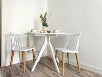 a table with two chairs and a white table with a plant at Logement Entier au Centre Ville in Évreux